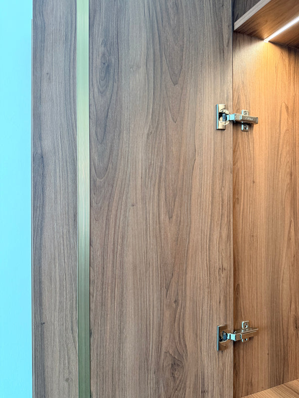 Close-up of wooden cabinet doors with a visible hinge of BLUM brand and brass door straightener to prevent warping in countries like Singapore with high humidity 