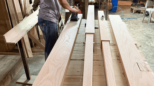 singaporean carpenter sanding solid wood posts ash oak for bed frame in workshop