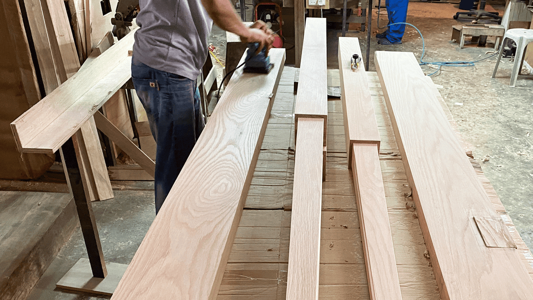 carpenter in singapore sanding solid oak wood to make bespoke bed