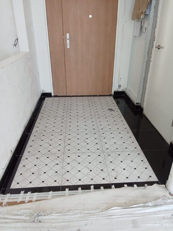HDB Floor with black and white diamond pattern tiles in a room with a wooden door. tiles from haffary. 