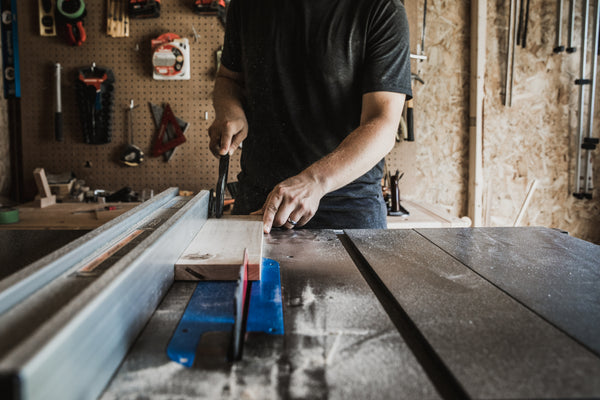carpenter in singapore cutting solid timber on table saw in HomeShake's workshop