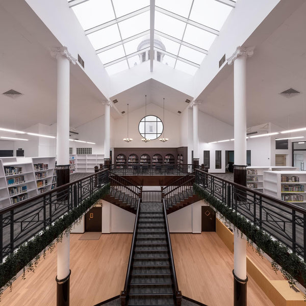 library in hwa chong singapore with white ceiling glass, metal staircase, wooden bookshelves by homeshake