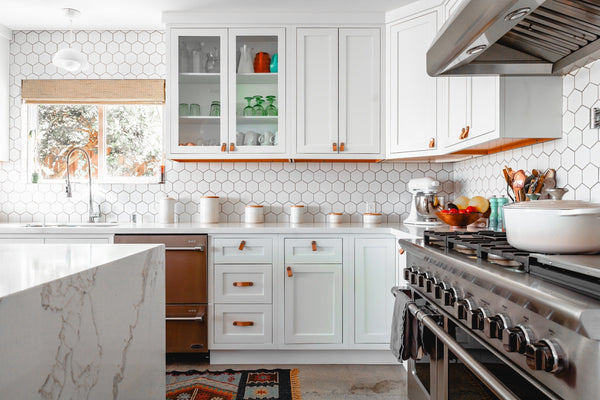 a renovated kitchen in singapore landed house with white shaker door panels and range cooker, marble island