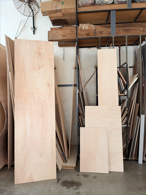 Stacks of wooden panels in a storage room with shelves and tools. Ready for cutting for diy projects in singapore