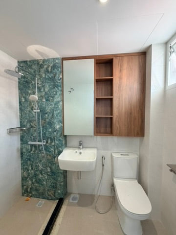 bathroom with shower, sink, toilet tiling by singapore tiler with accent wall in green