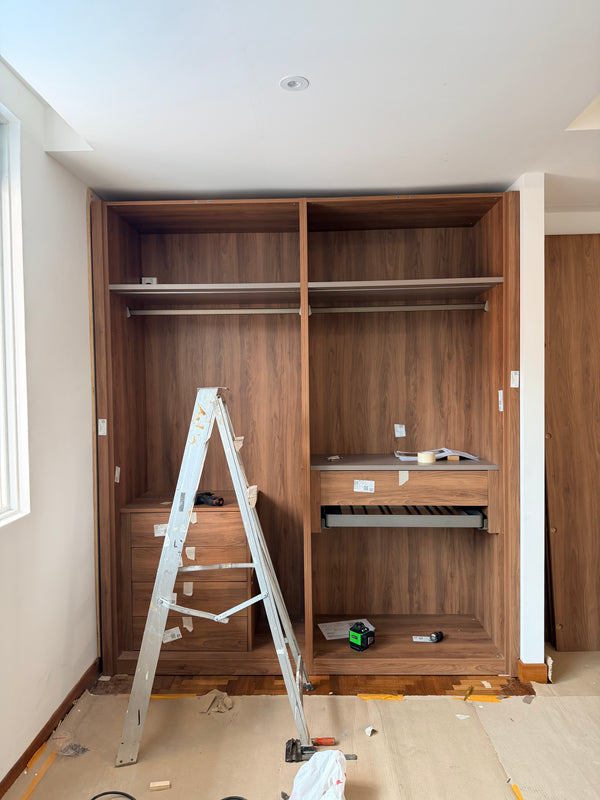 Wooden wardrobe installation in bedroom in singapore with tools and materials on the floor
